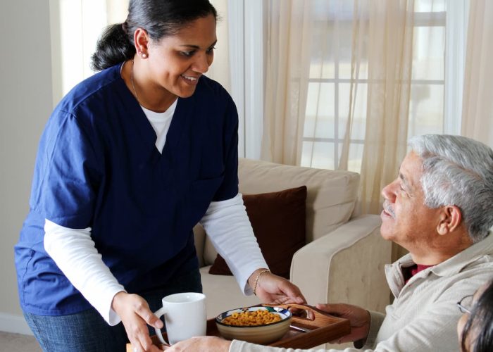 Novellus Clairemont | Senior man with caregiver eating lunch